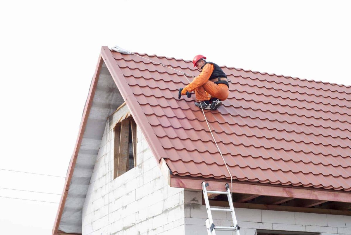 Builder performs installation gable roof tiles of metal - benefits of choosing tile roofing