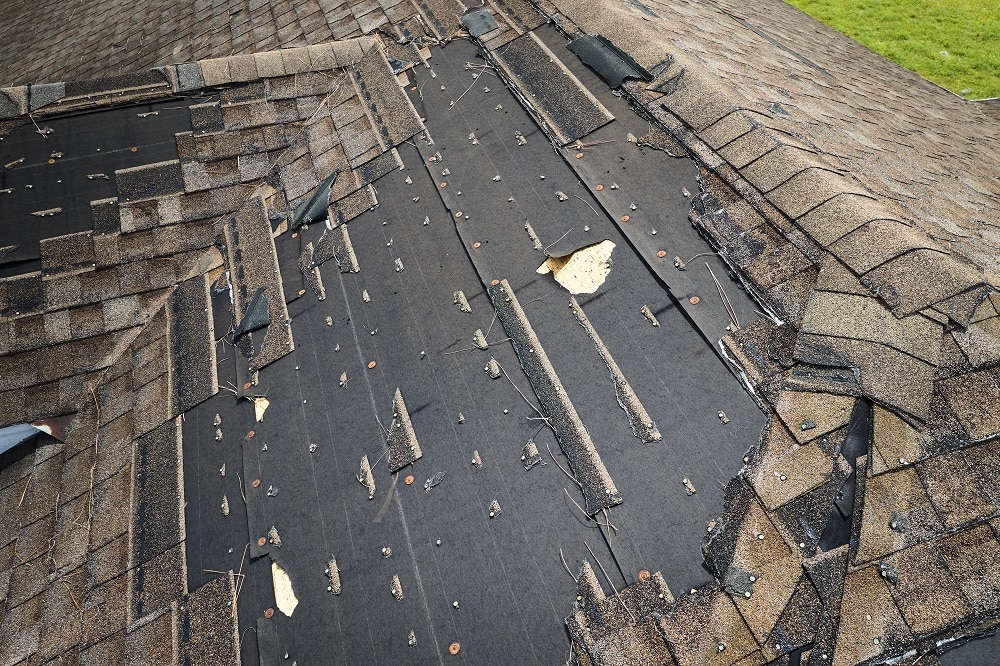 Damaged roof with missing shingles after a storm
