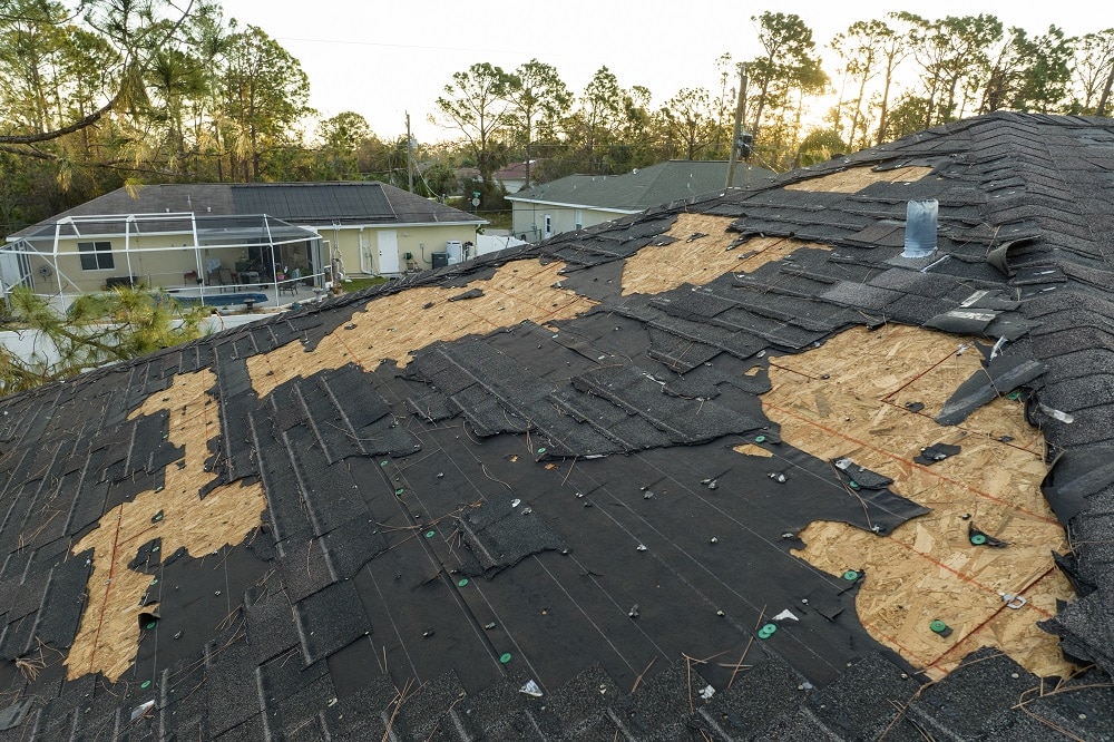 Roof with missing asphalt shingles after storm damage