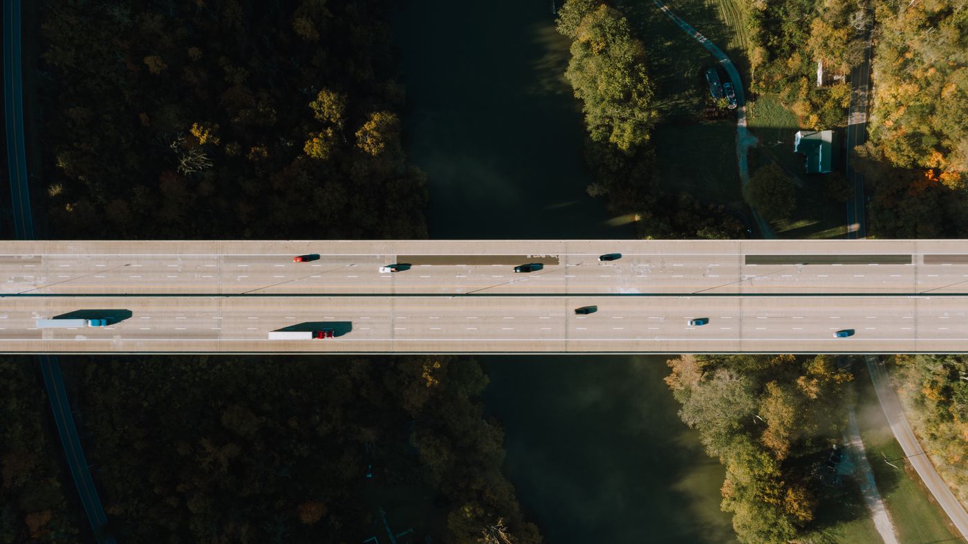 Aerial view of a highway bridge over trees and water