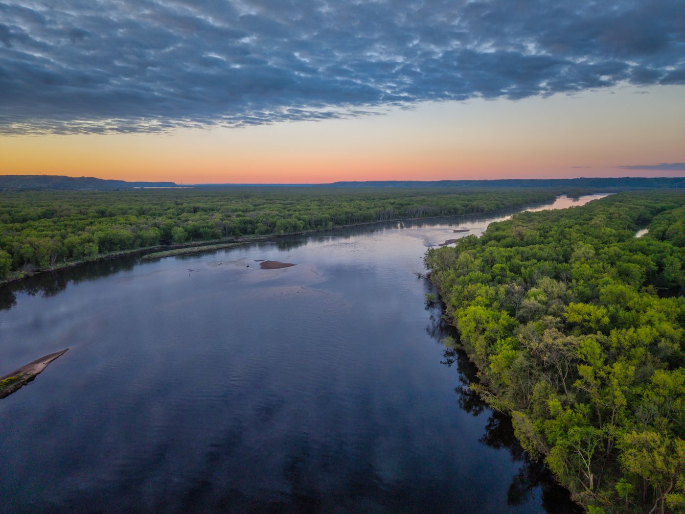 Aerial view of a wide river at sunset