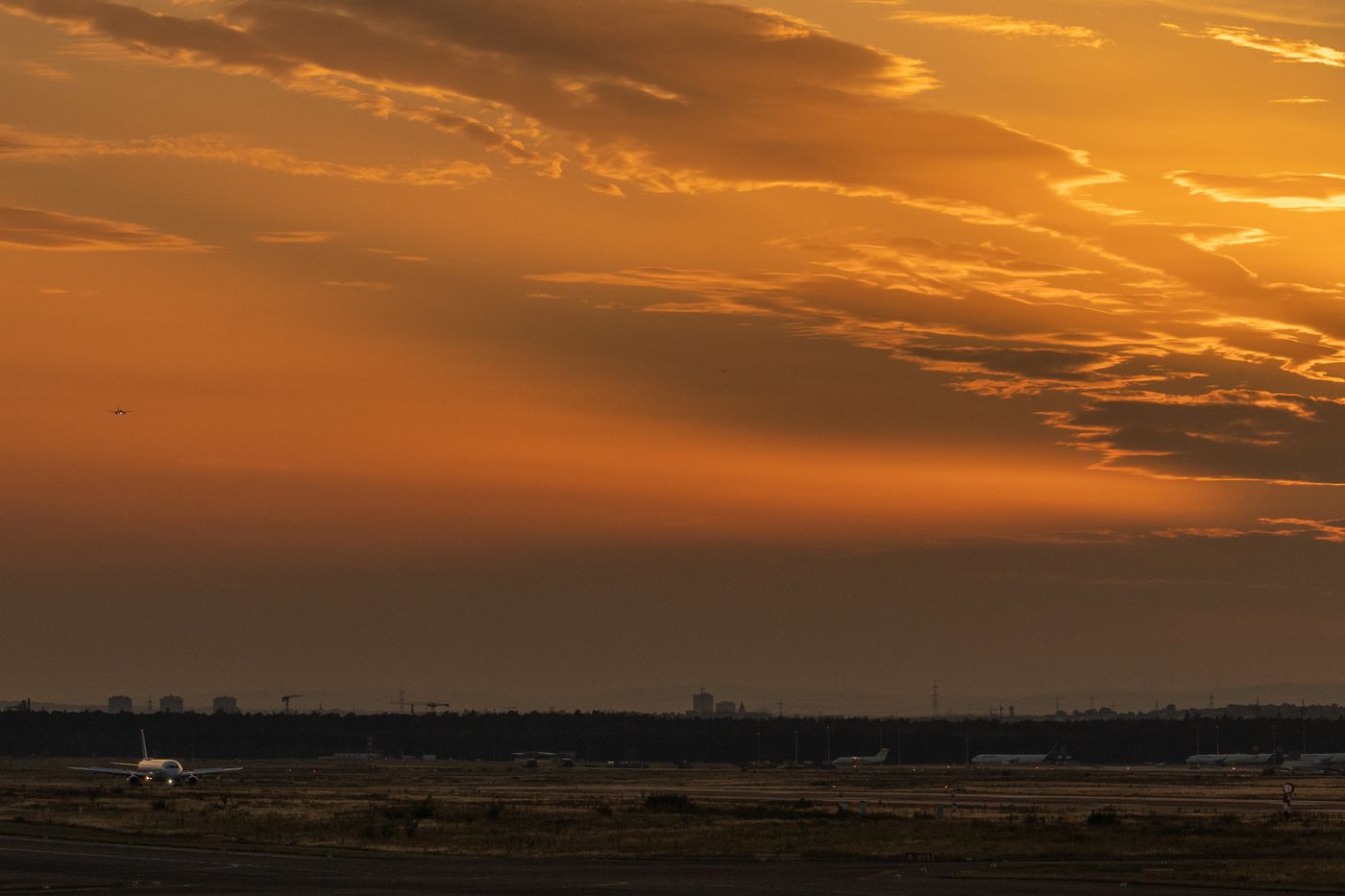 Airfield under an orange sunset sky