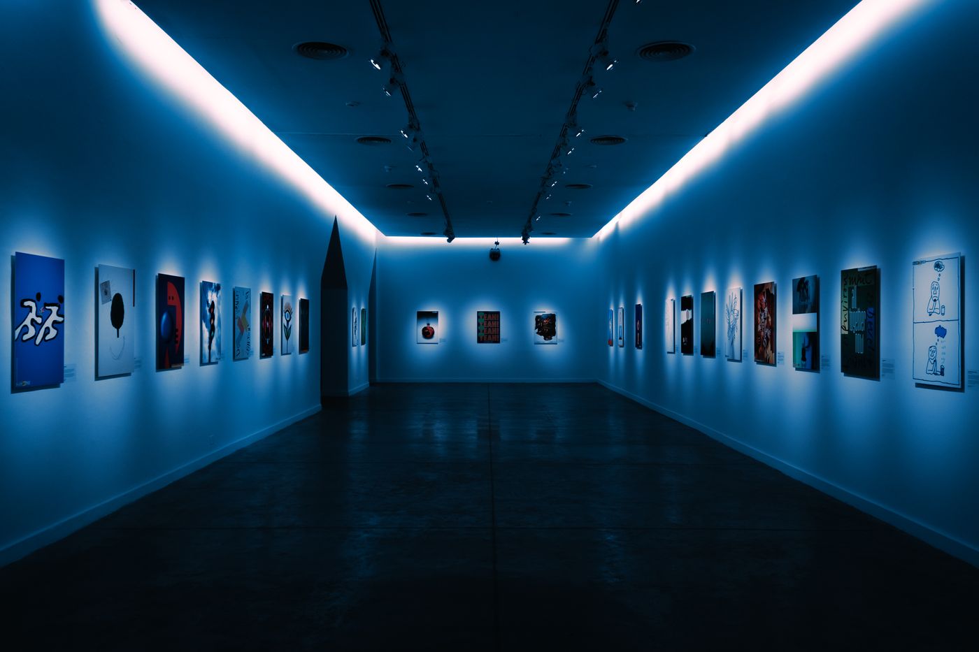 Art gallery with framed works on blue walls