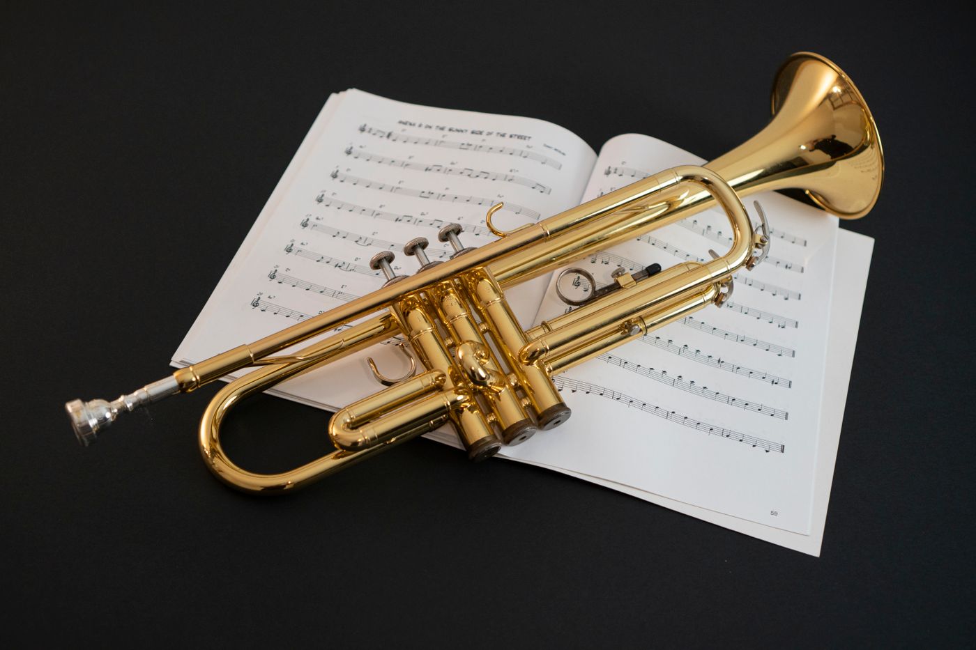 Brass trumpet resting on sheet music
