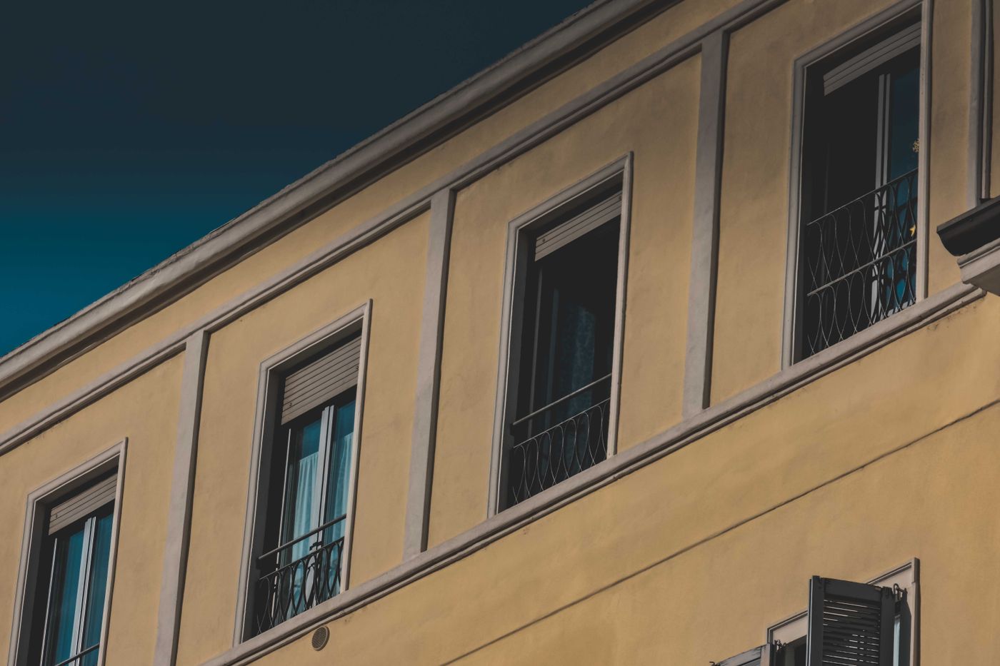 Building facade with large windows and a stucco finish