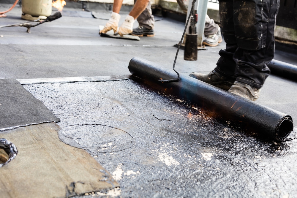 Roofer torching down bitumen roofing felt