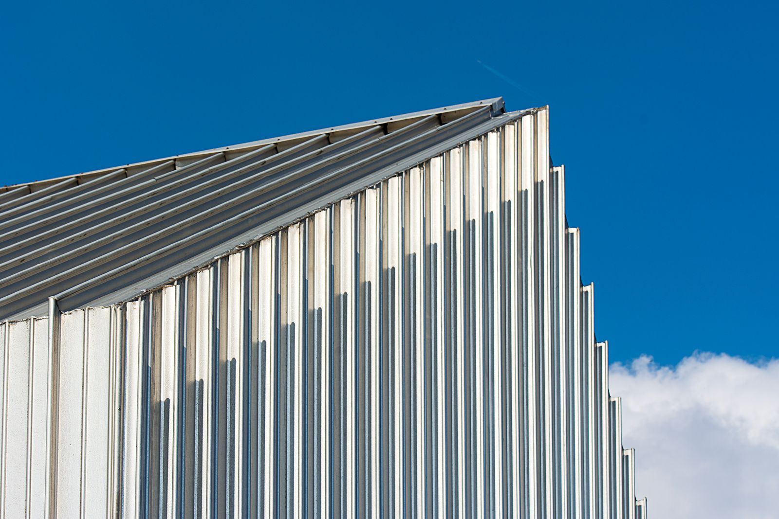Corrugated steel facade against a blue sky