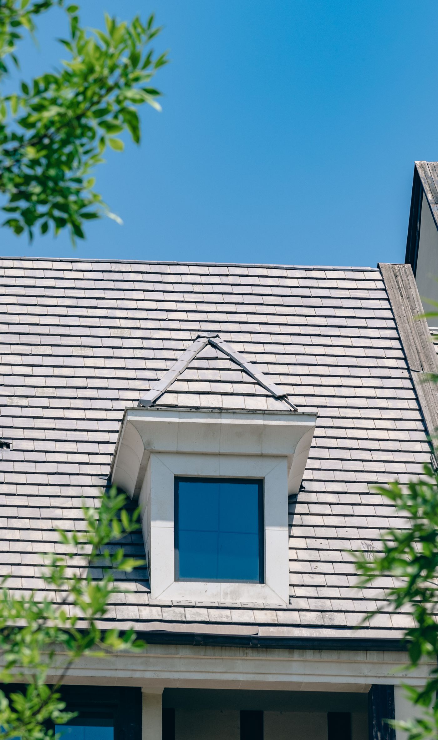 Flat gray shingles around a dormer window