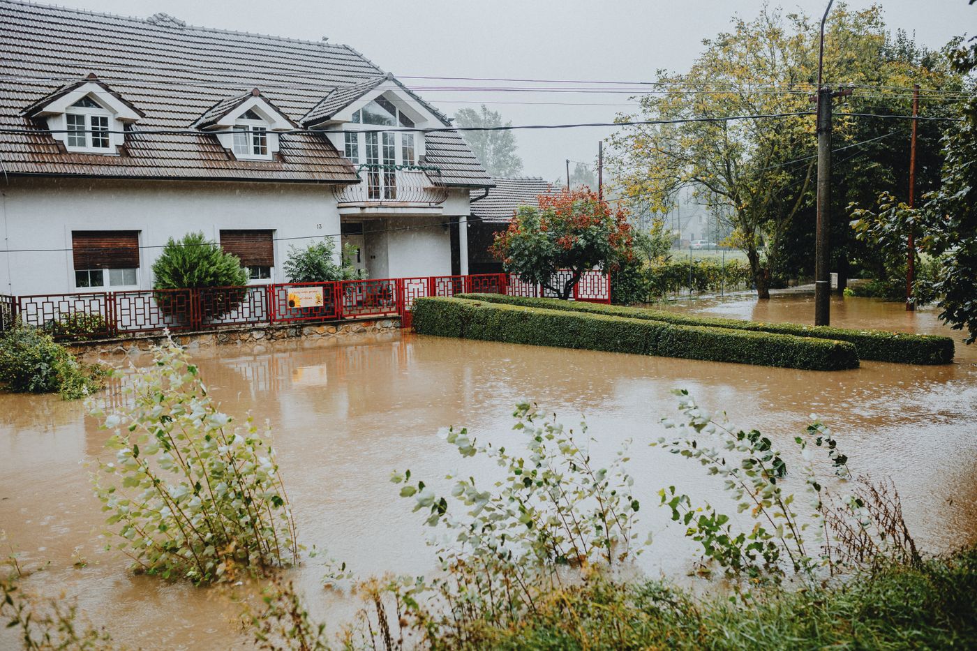 Floodwater in front of a two-story house after heavy rain