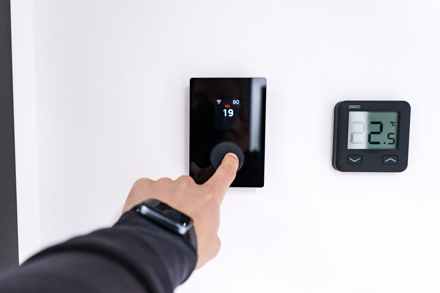 Hand adjusting a wall thermostat