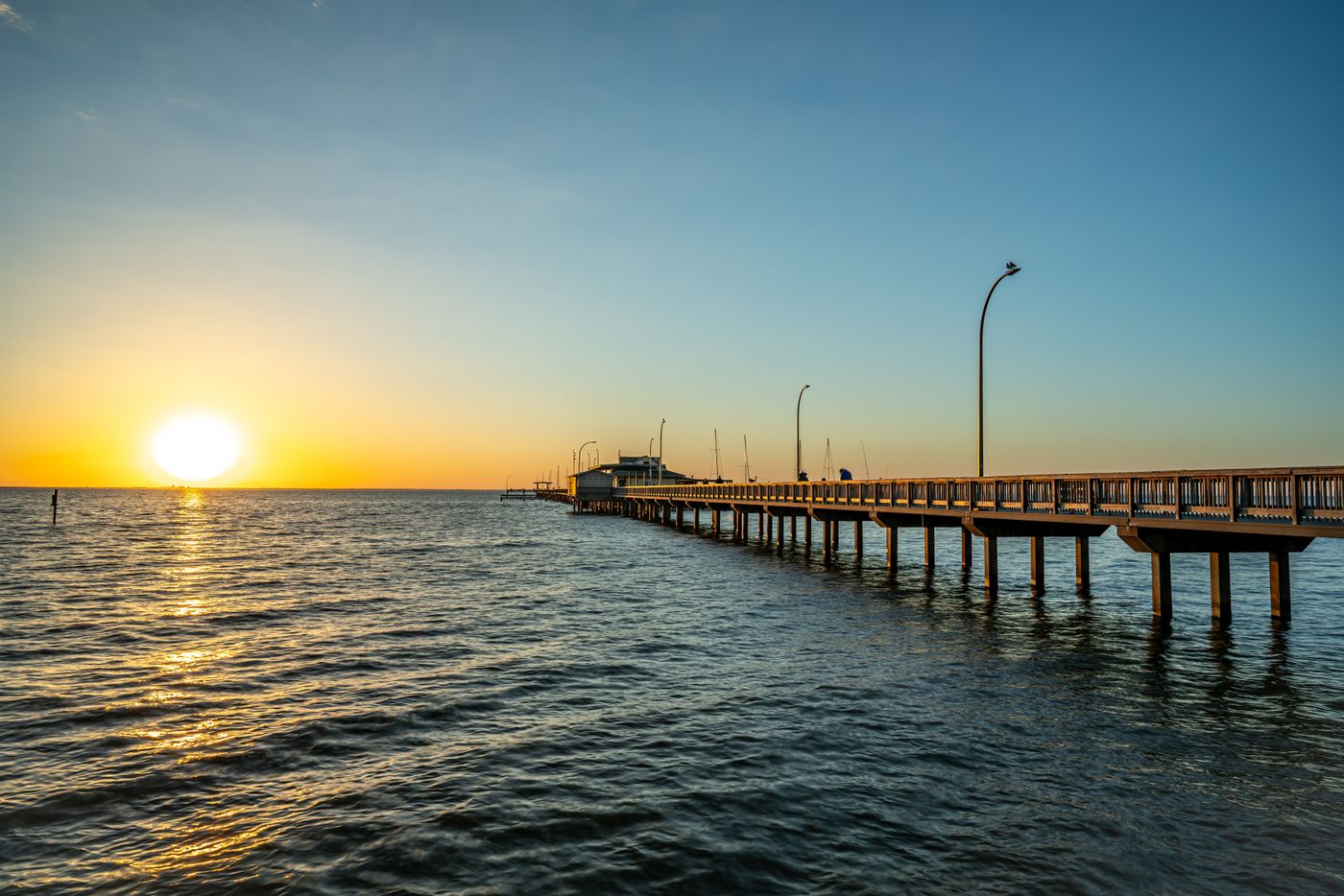 Long pier over the water at sunset