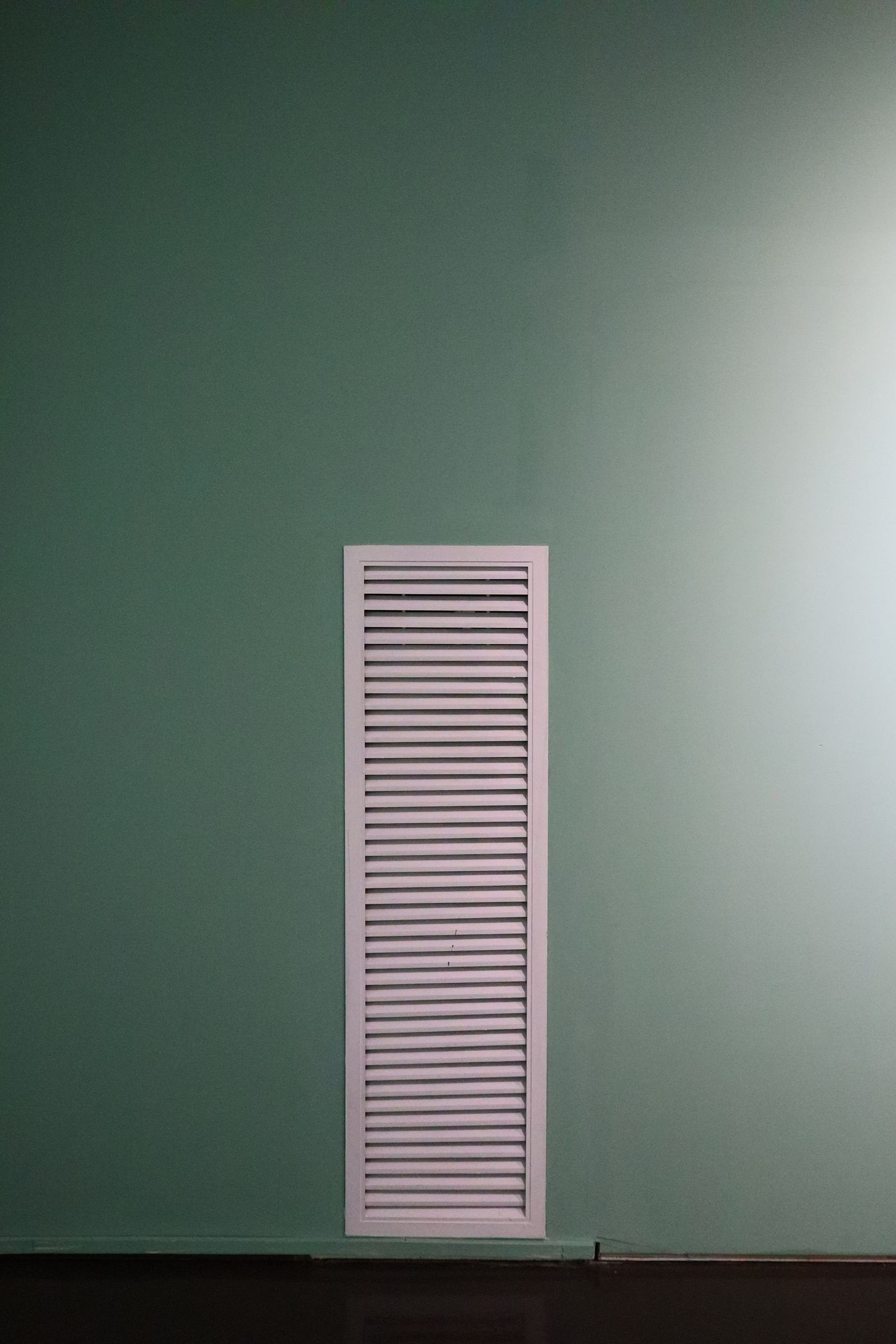 Louvered vent on a green wall