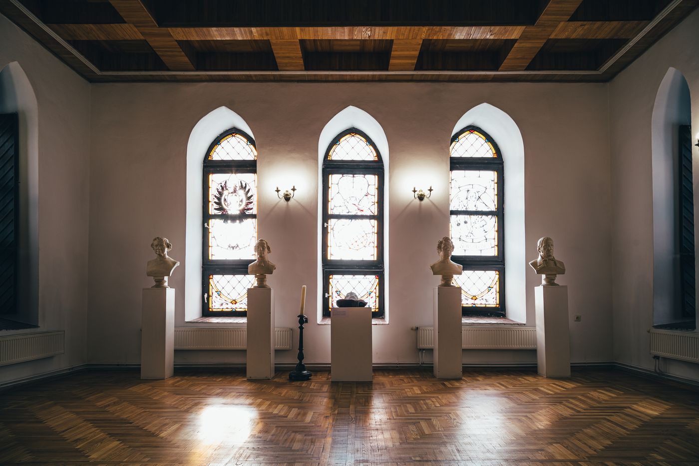 Museum hall with stained glass windows and busts