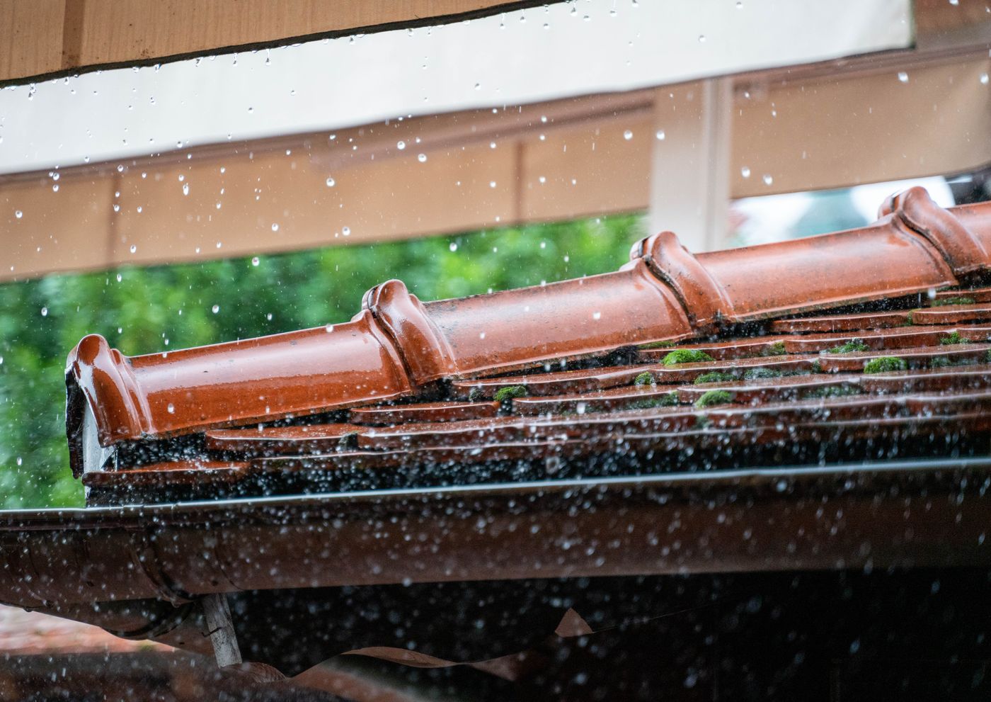 Rain falling on a tile roof and gutter