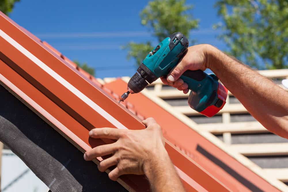 Roofer fixing panels on a roof