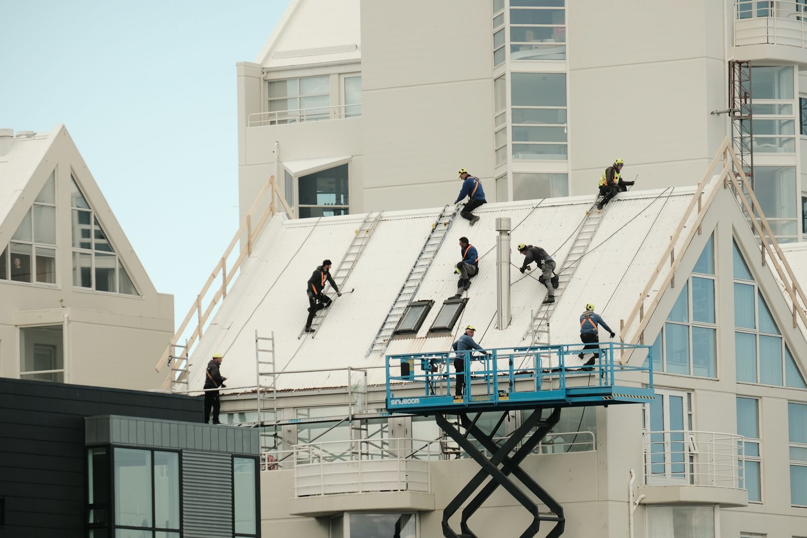 Roofers working across a large building roof