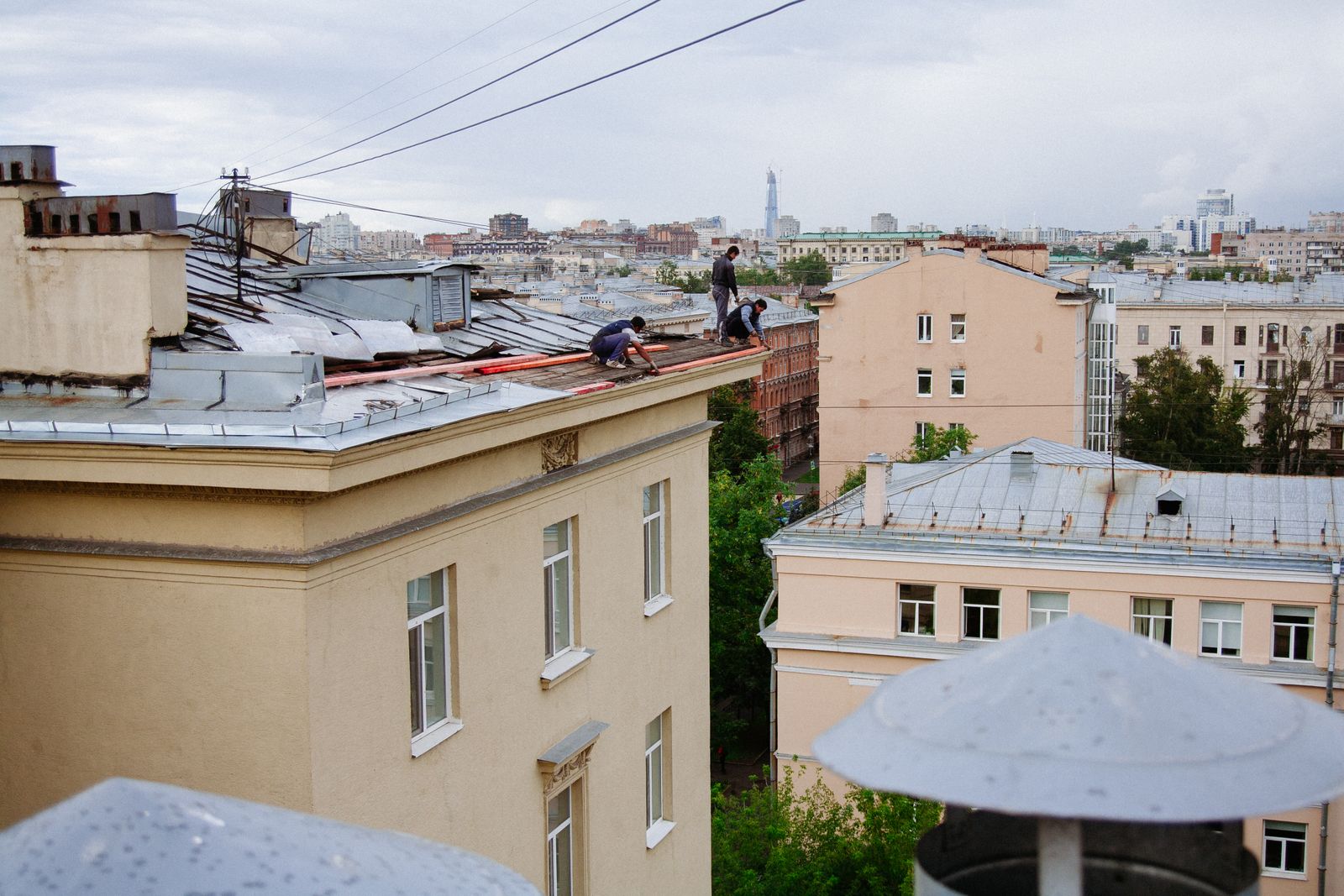 Roofers working on a city rooftop
