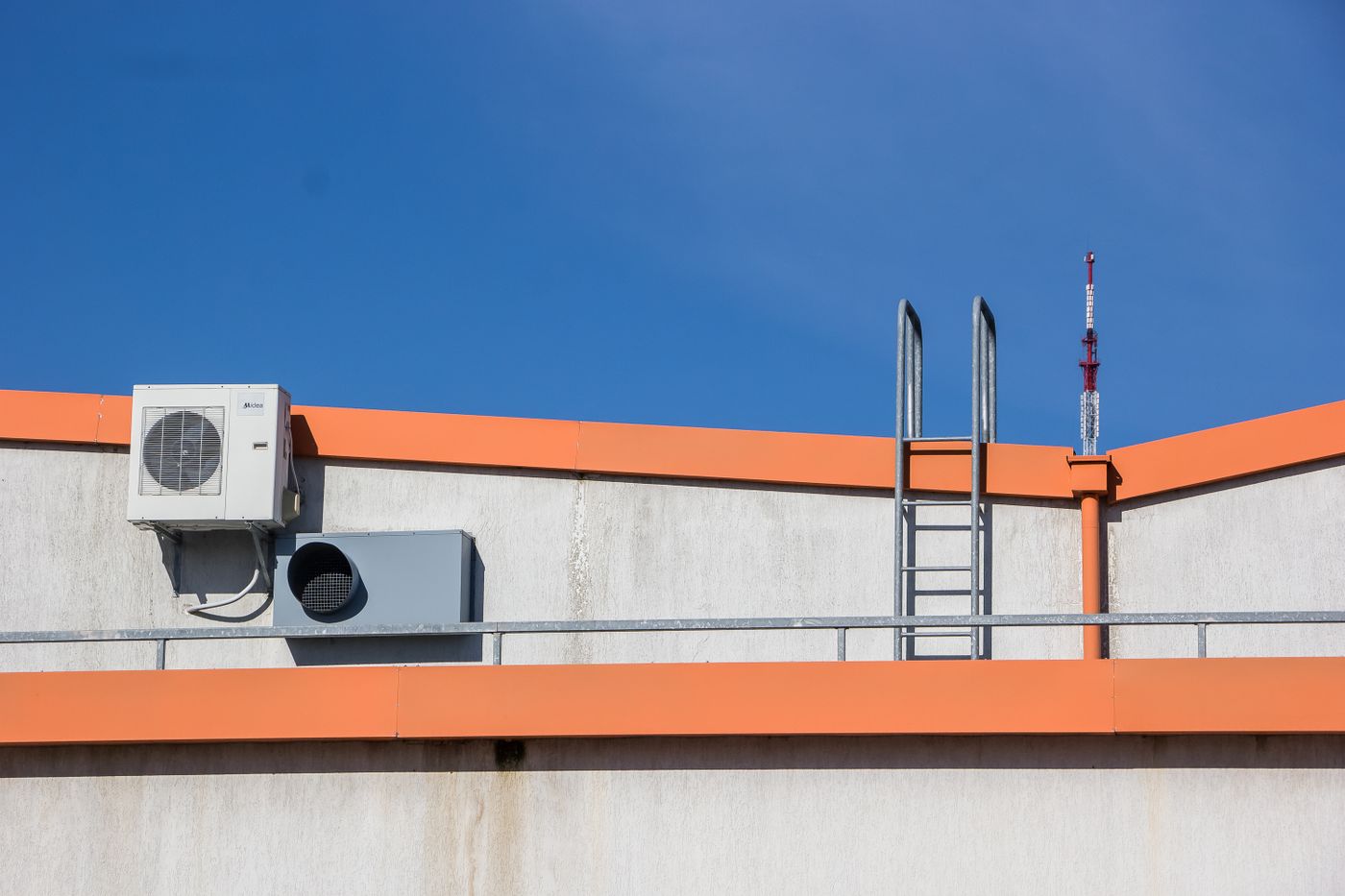 Rooftop air conditioning unit beside a ladder