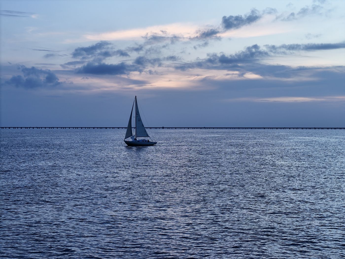 Sailboat on a wide lake at sunset