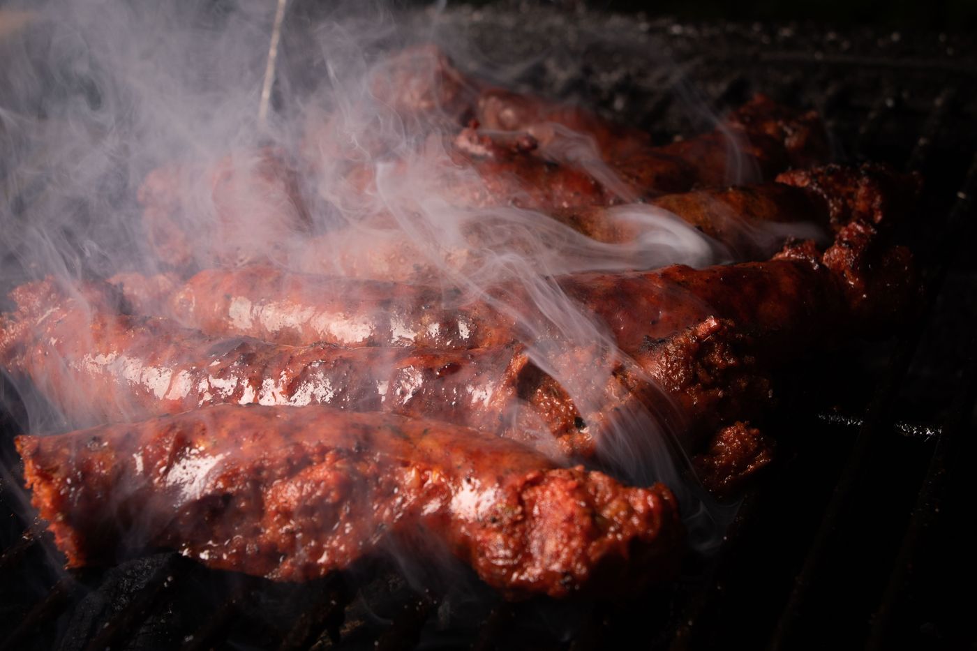 Sausages smoking on a grill