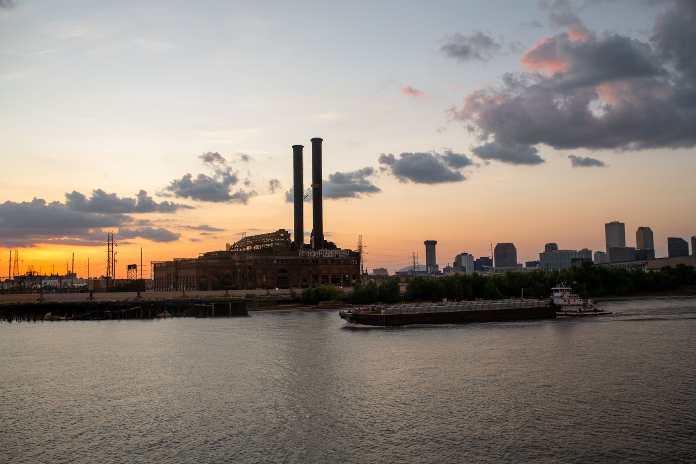Smokestacks beside a river at sunset