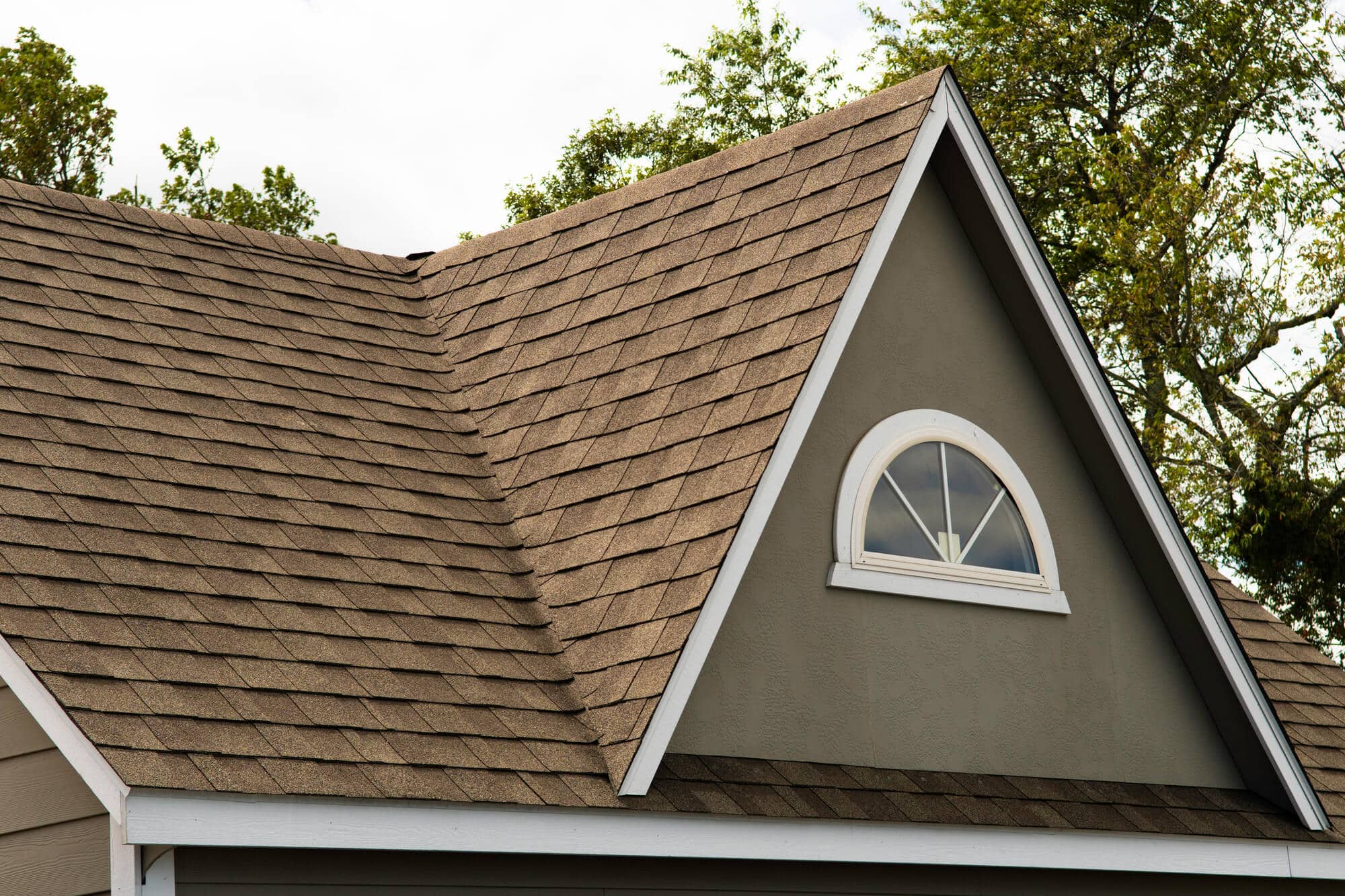 Close view of an asphalt shingle roof and dormer