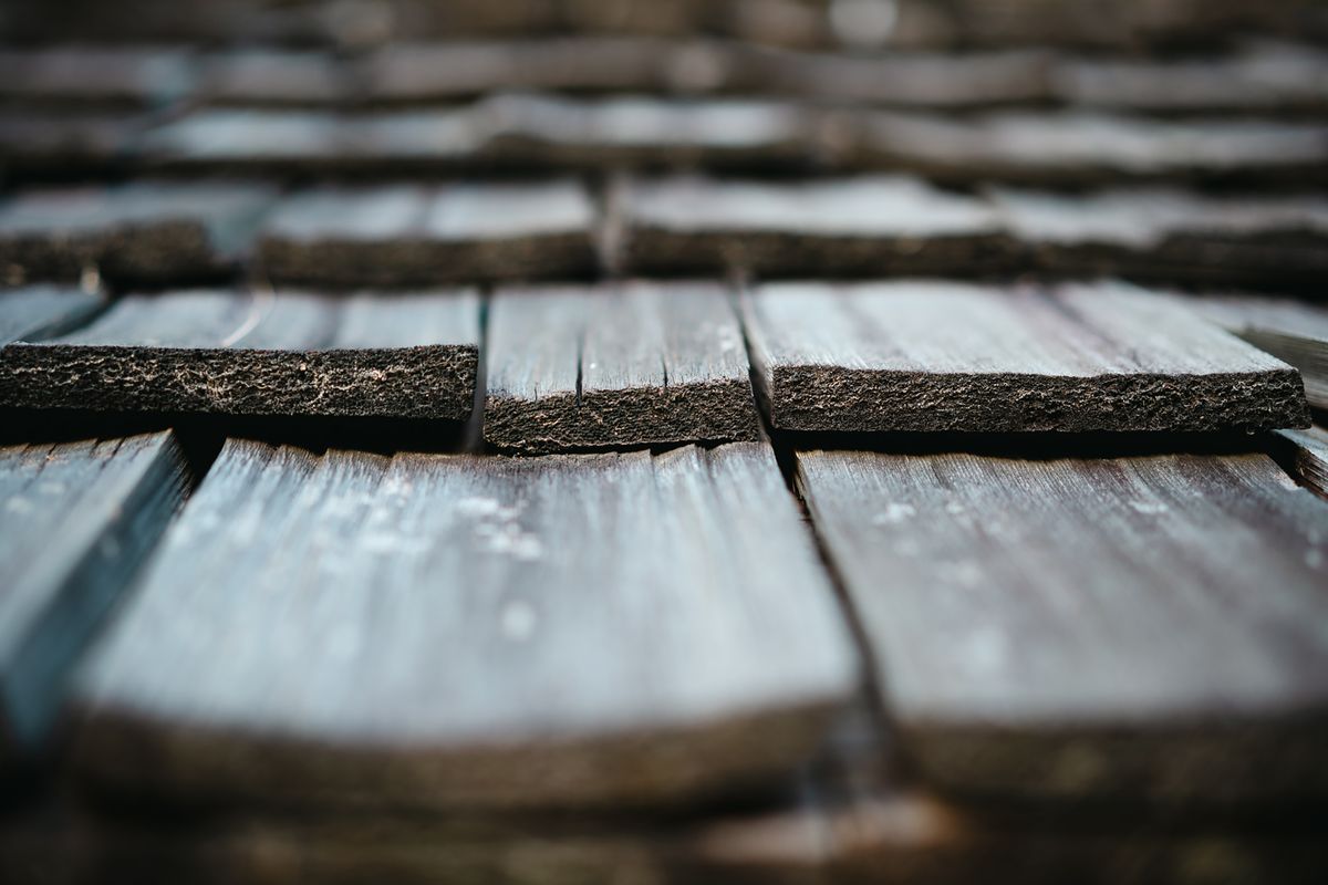 Close-up of weathered wood roof shingles showing natural aging and texture