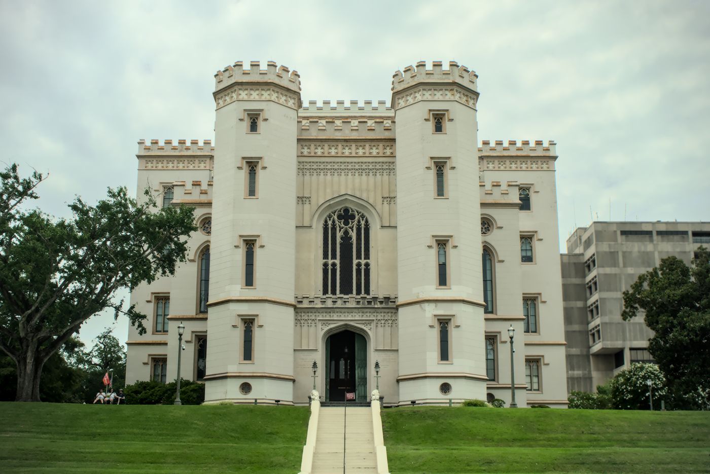 White castle-style building with towers on a green lawn