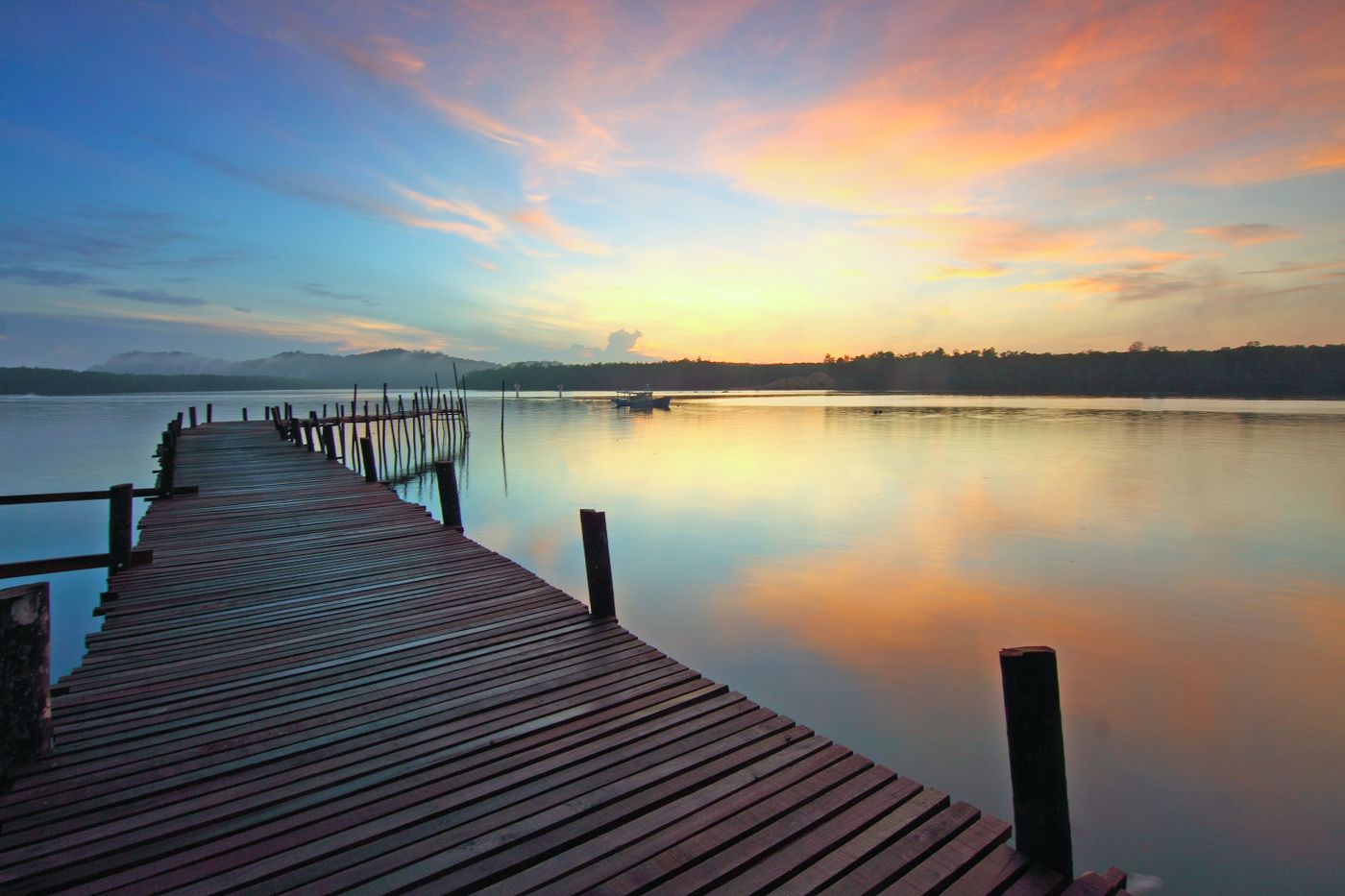 Wooden pier stretching into a lake at sunset